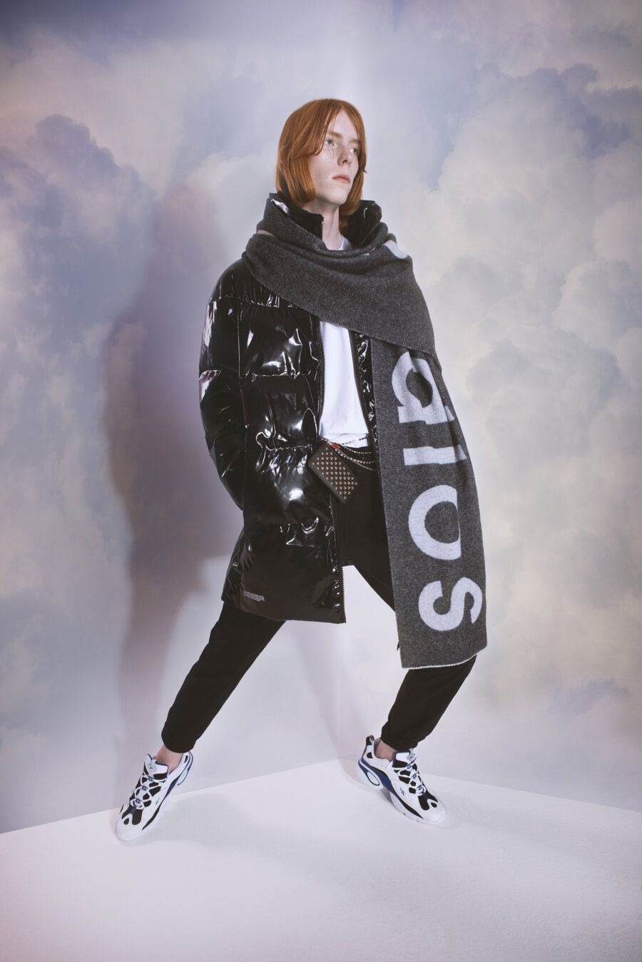 A model standing in front of a cloud background