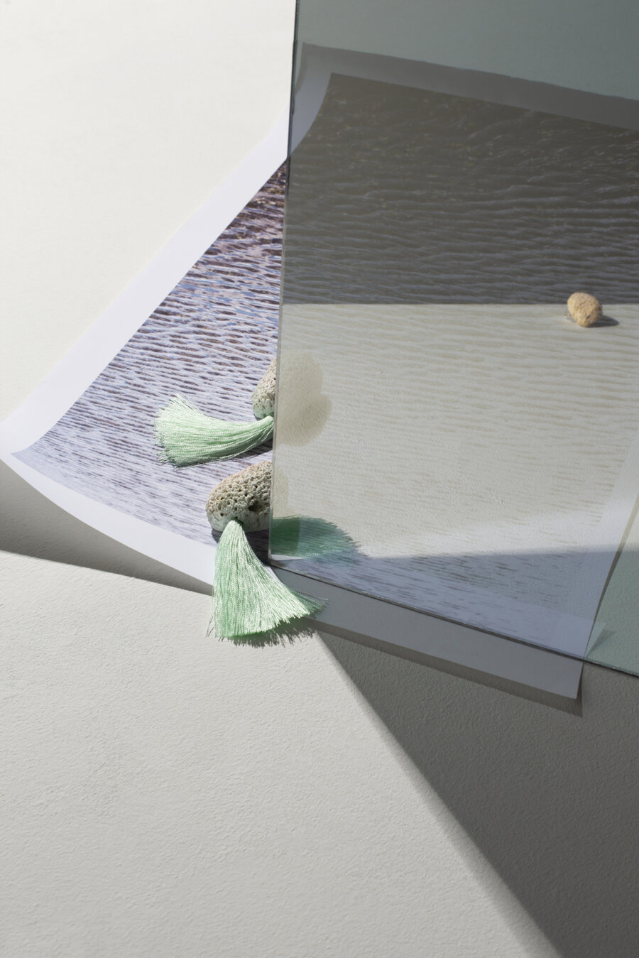 Print of beach scape with mirror on top giving a reflection. A pair of Kate Trouw earrings sit on top