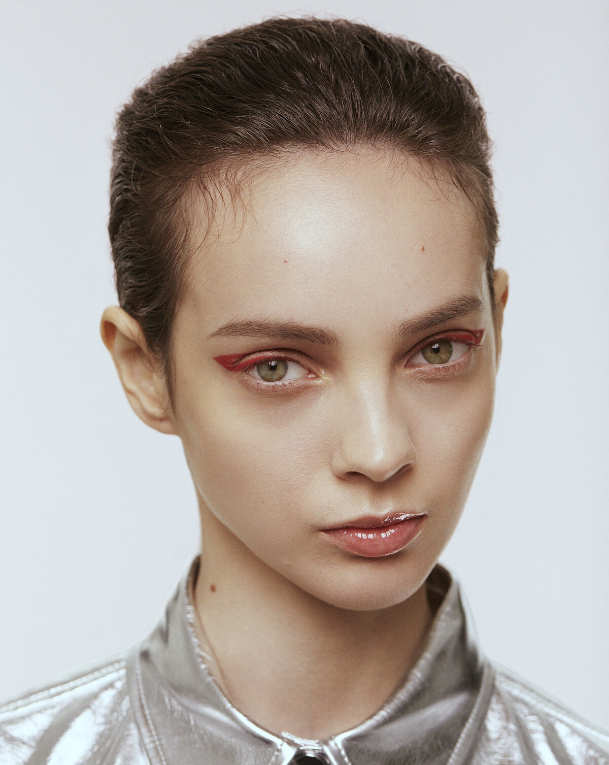 A portrait of a woman wearing a metallic silver shirt