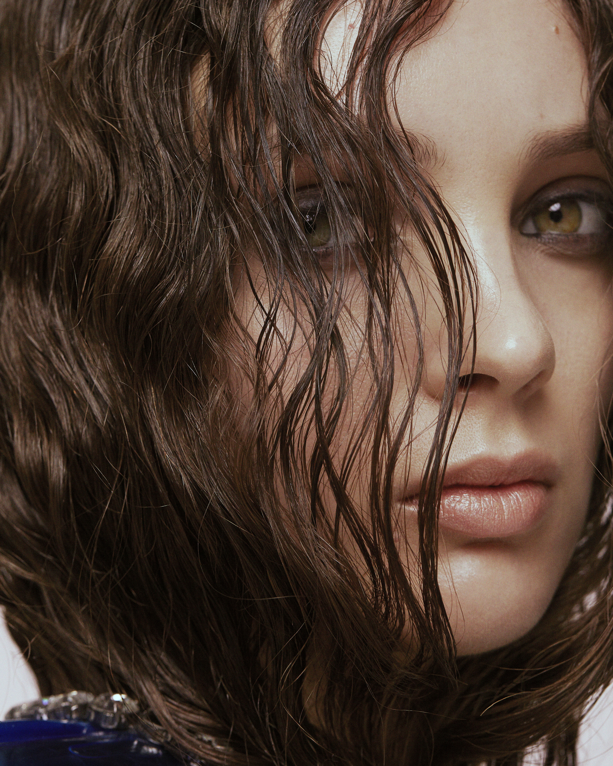 Close up of a woman's face behind curly hair