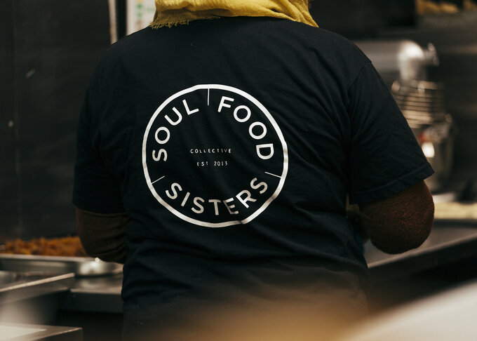 A back print of the Soul Food Sisters logo on a black t-shirt