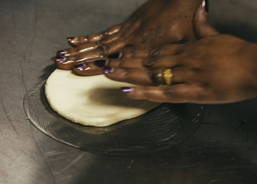 Two hands rolling out dough