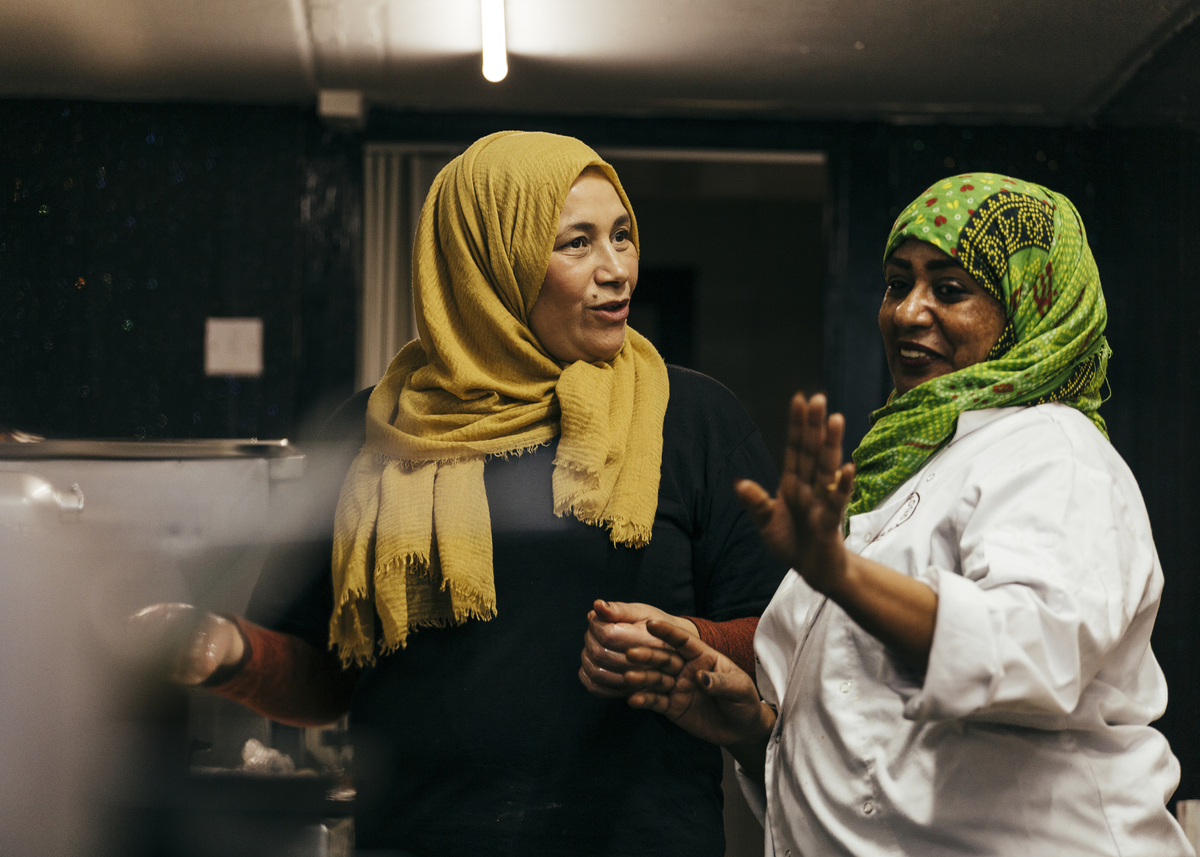 Two women in a kitchen talking together
